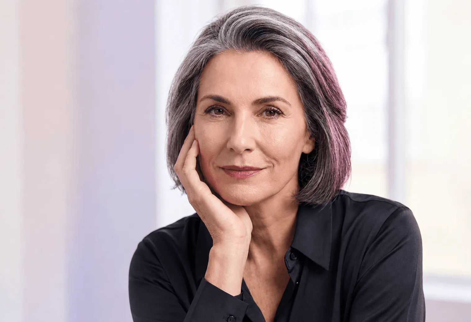 Woman in her fifties studying the jowls and sagging skin along her jawline in Covington, KY