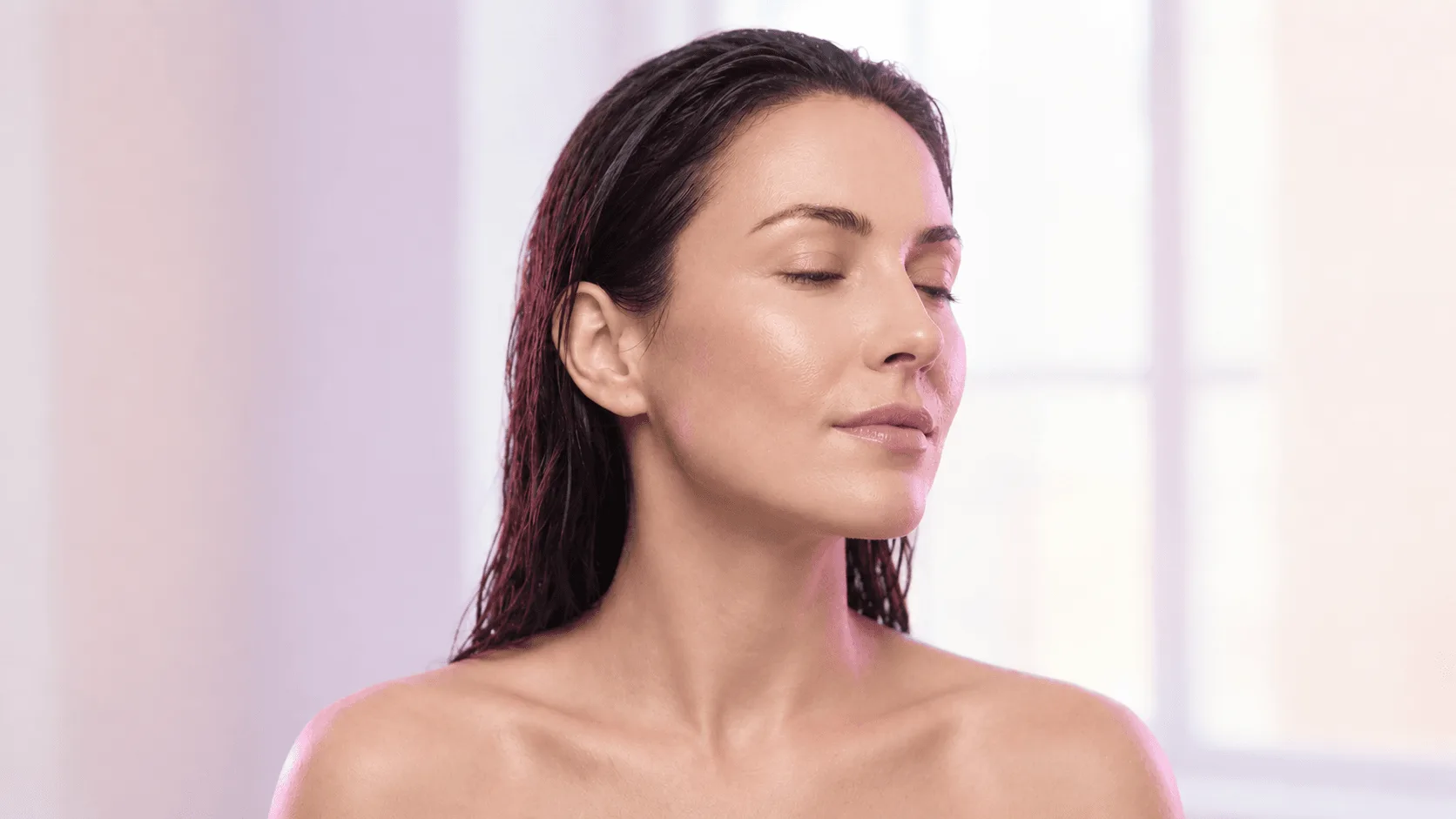 Woman checking her dull, dehydrated complexion in natural light before skin treatment in Covington, KY